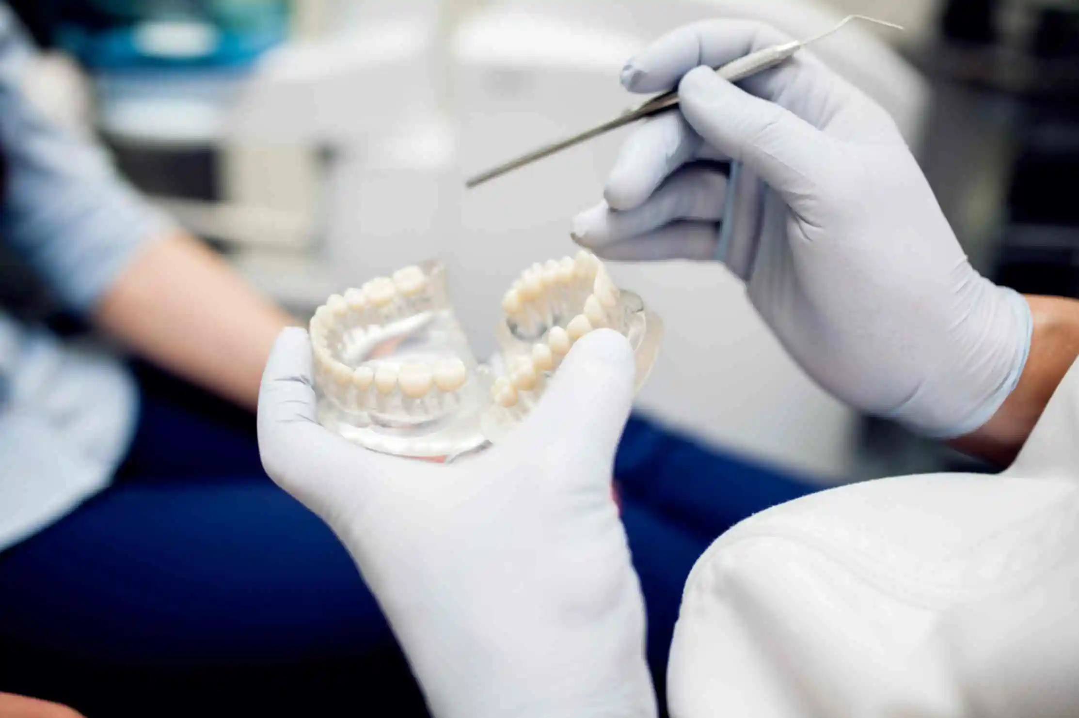jpeg-optimizer_model-tooth-dentist-doctor-shows-patient-tooth-reception-dentist-s-office-300x200